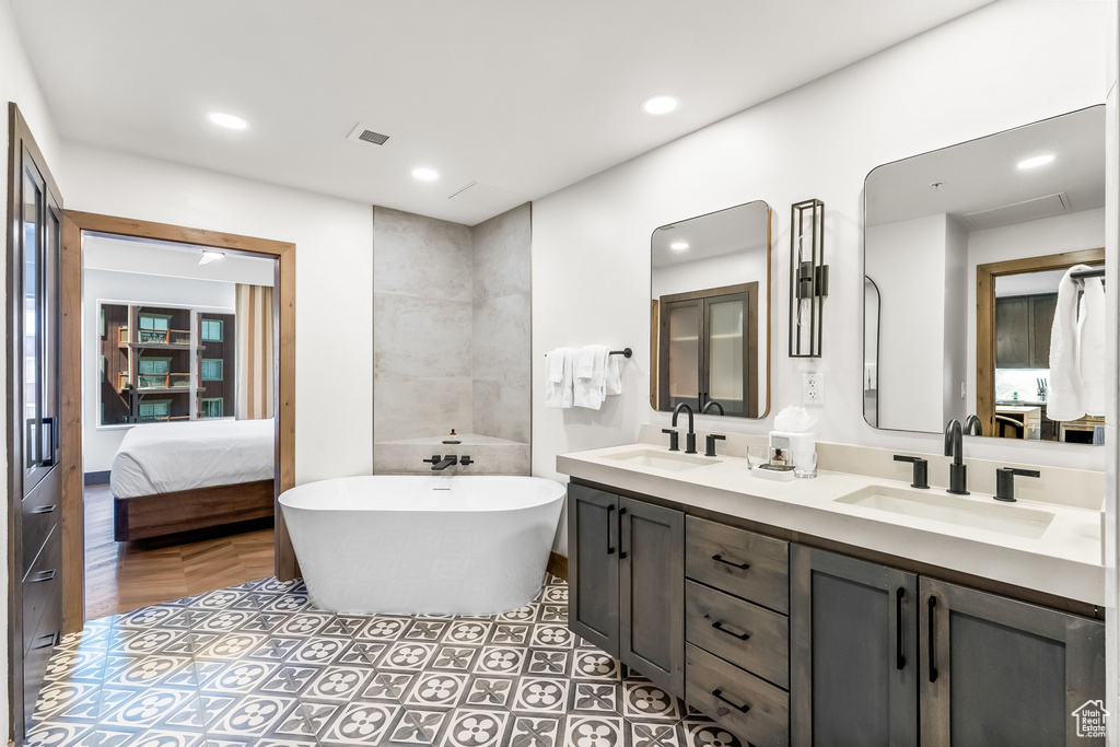 Bathroom featuring tile flooring, dual sinks, a bath, and large vanity