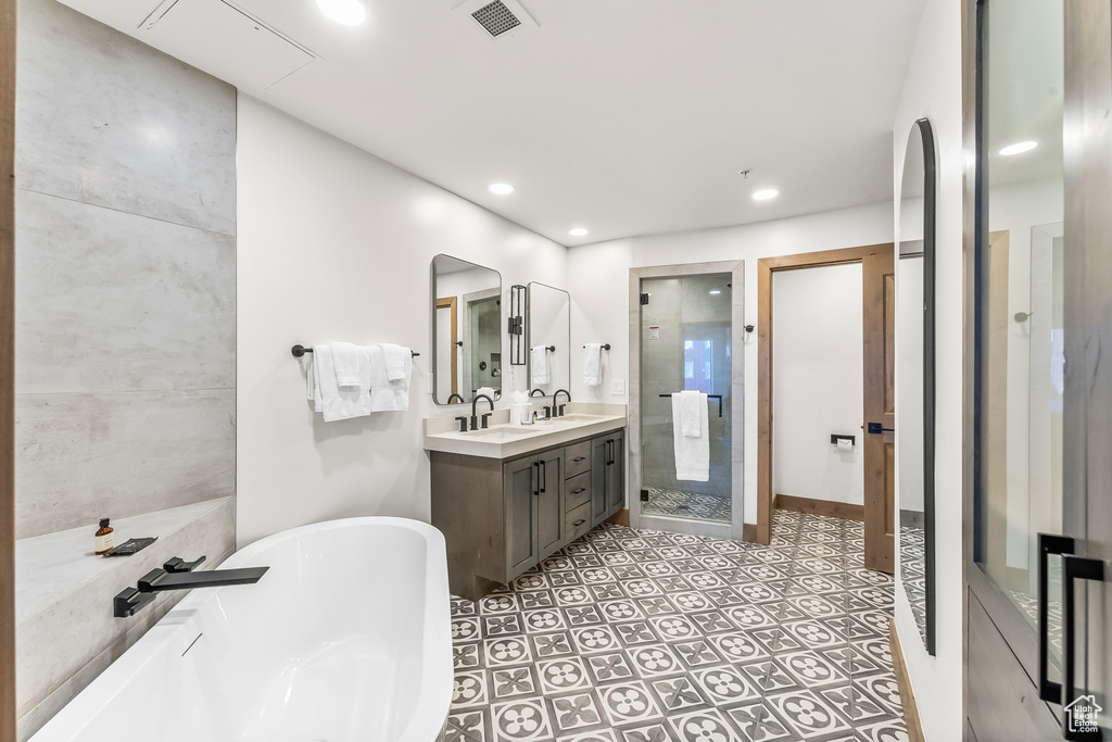 Bathroom with tile flooring, vanity, and plus walk in shower
