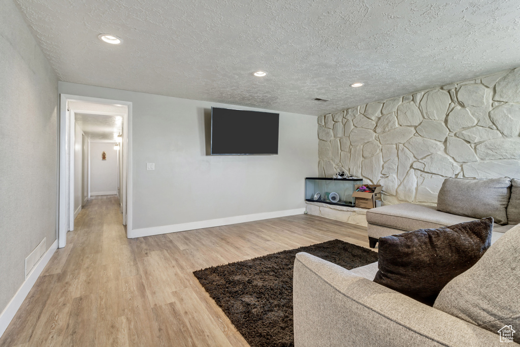 Living room featuring a textured ceiling and light hardwood / wood-style floors