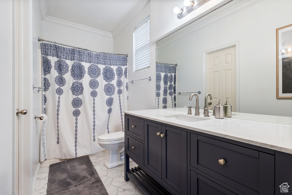 Bathroom featuring tile flooring, ornamental molding, vanity, and toilet
