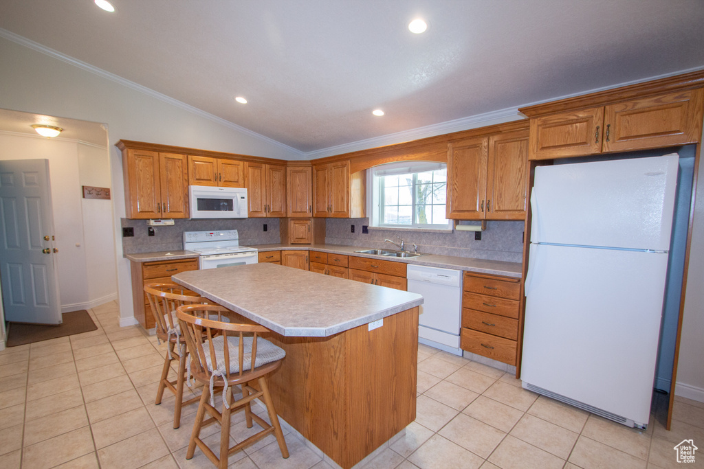 Kitchen featuring a center island, tasteful backsplash, white appliances, and lofted ceiling
