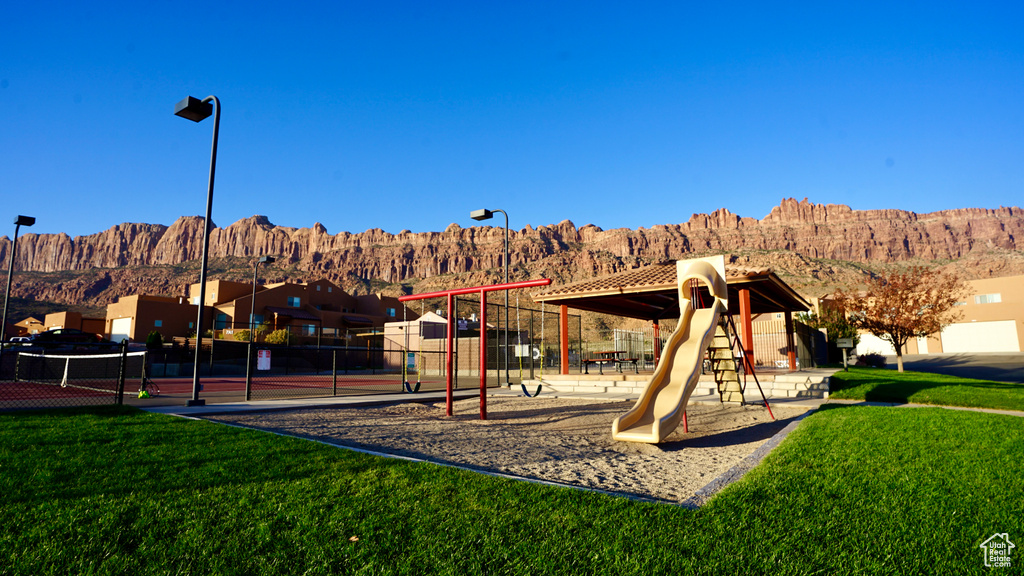 View of nearby features featuring a mountain view, a playground, and a yard