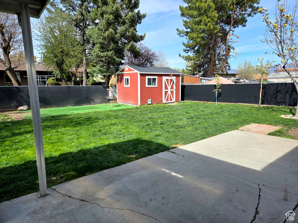 View of yard with a storage shed and a patio