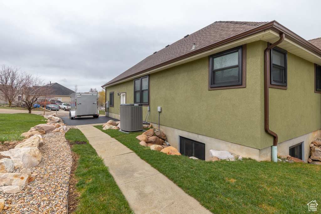 View of home\\\\\\\'s exterior featuring central air condition unit and a lawn