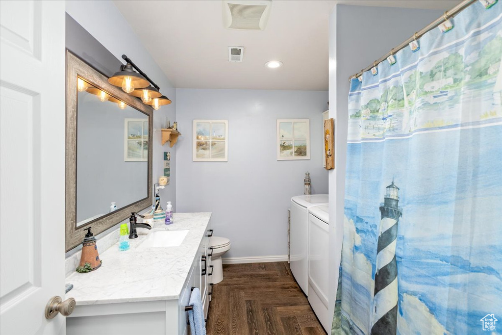 Bathroom featuring oversized vanity, independent washer and dryer, toilet, and parquet floors