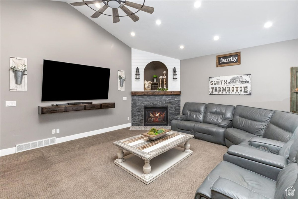 Living room featuring a fireplace, ceiling fan, lofted ceiling, and carpet flooring