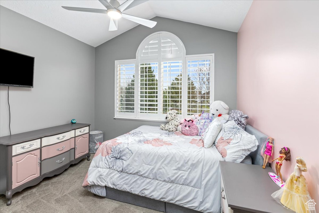Bedroom with light colored carpet, vaulted ceiling, and ceiling fan