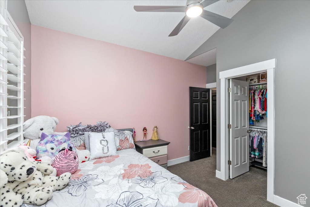 Bedroom featuring a closet, ceiling fan, dark carpet, and vaulted ceiling