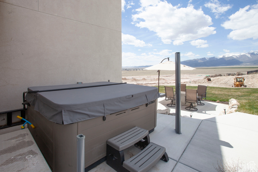 View of terrace featuring a mountain view and a hot tub