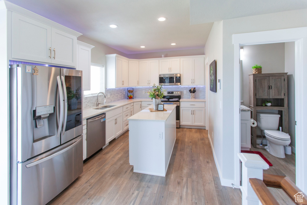 Kitchen with white cabinets, appliances with stainless steel finishes, and a center island