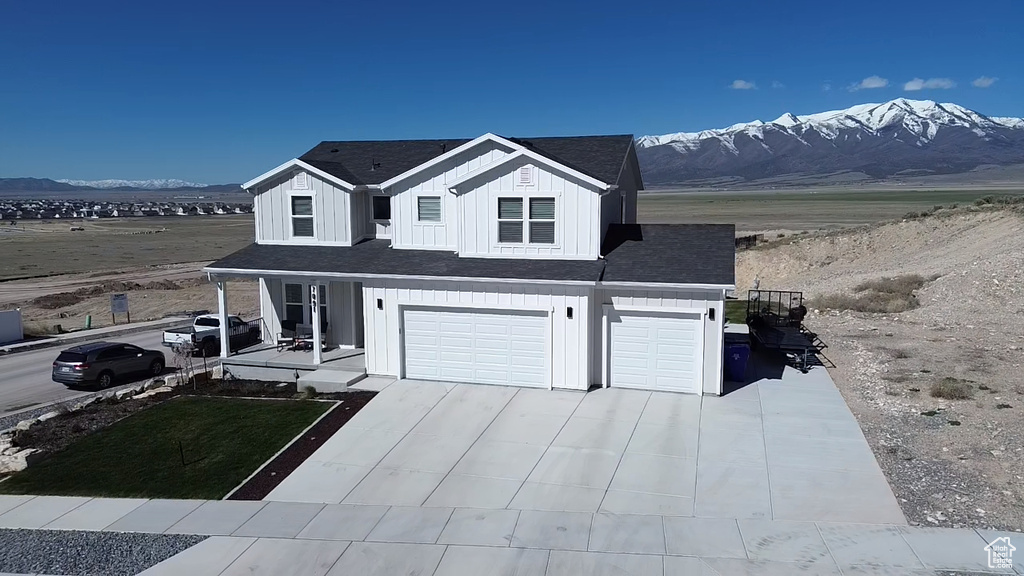 View of front of home with a mountain view and a garage