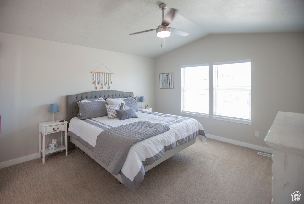 Bedroom with carpet flooring, ceiling fan, and vaulted ceiling