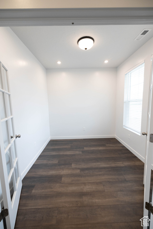 Unfurnished room featuring dark hardwood / wood-style floors and french doors