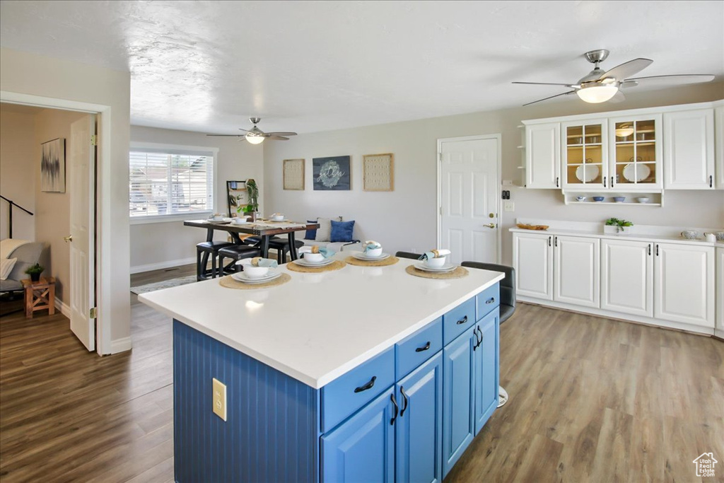 Kitchen with a center island, light hardwood / wood-style flooring, ceiling fan, and blue cabinetry