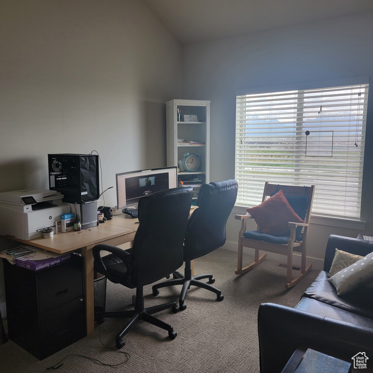 Home office featuring vaulted ceiling and carpet flooring