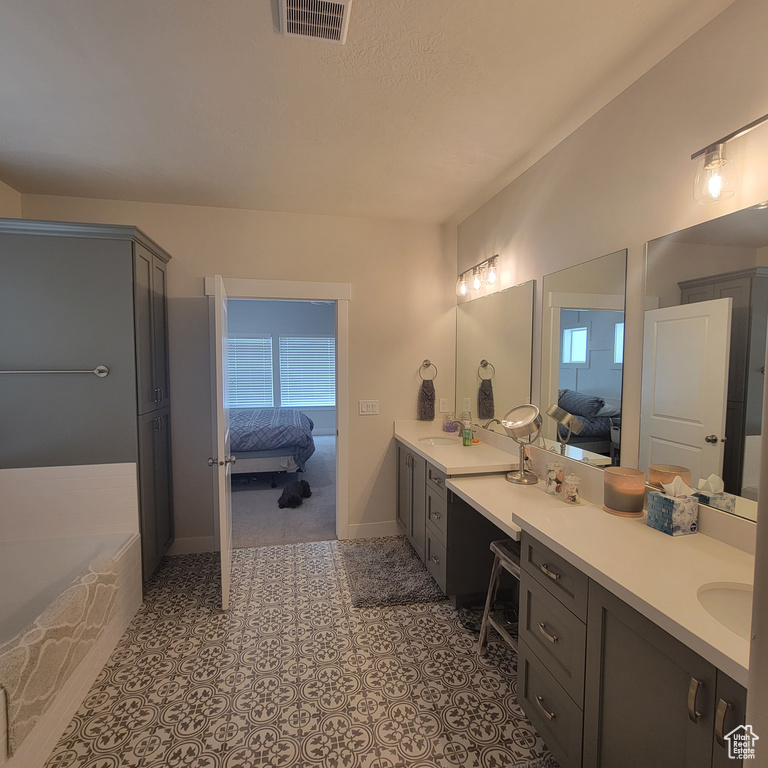 Bathroom featuring a bathing tub, tile floors, and double sink vanity