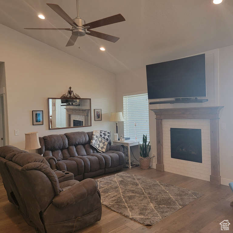Living room featuring ceiling fan, dark hardwood / wood-style floors, and lofted ceiling
