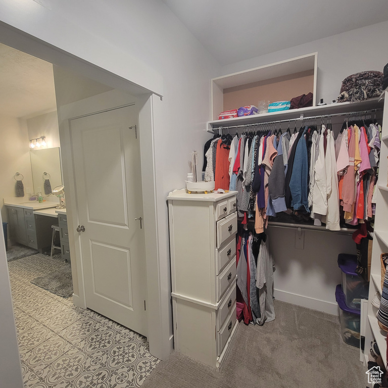 Walk in closet featuring sink and light tile floors
