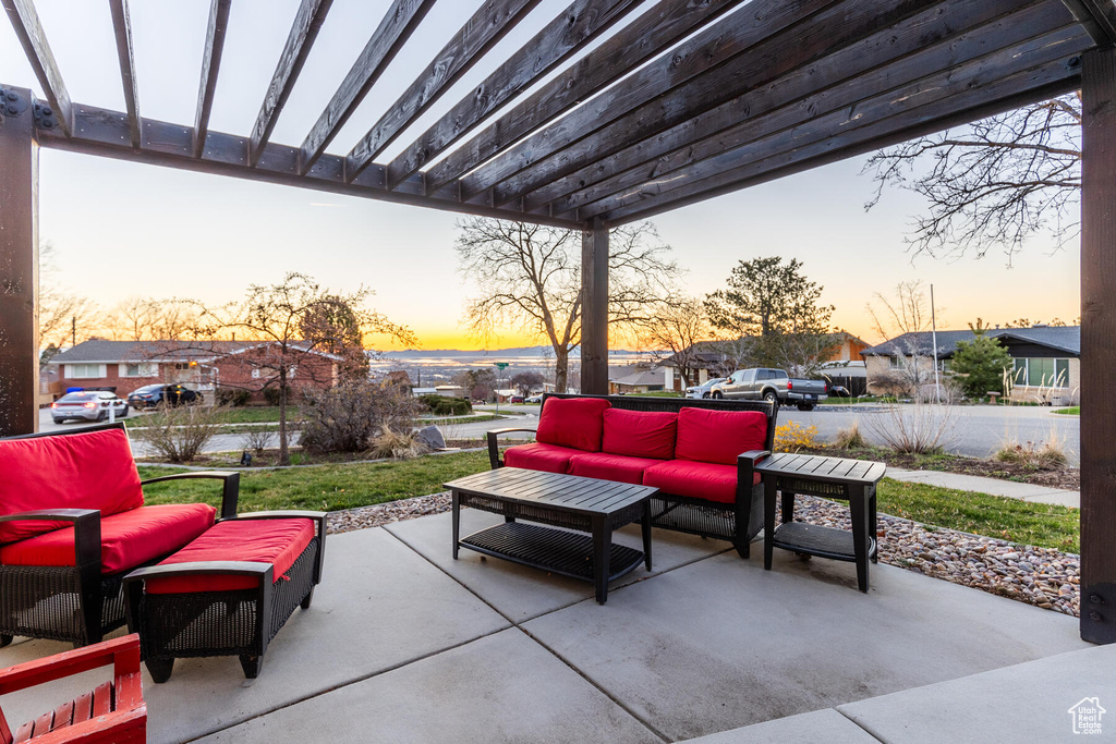 Patio terrace at dusk featuring an outdoor living space and a pergola