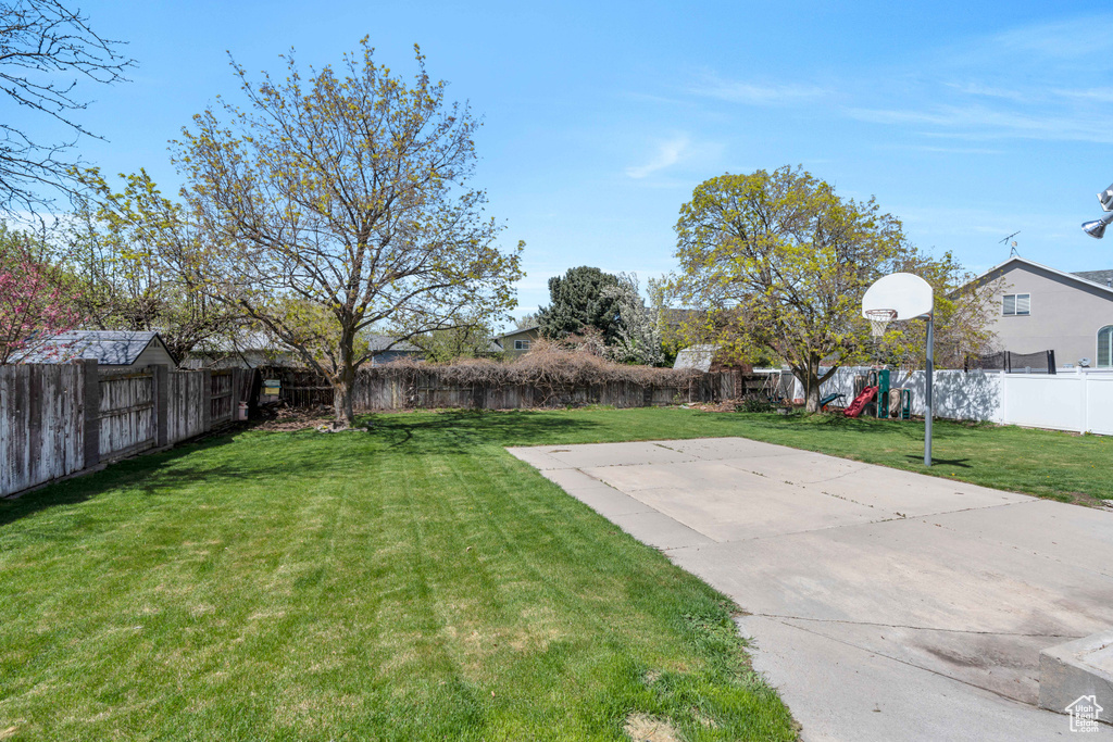 View of yard featuring basketball hoop