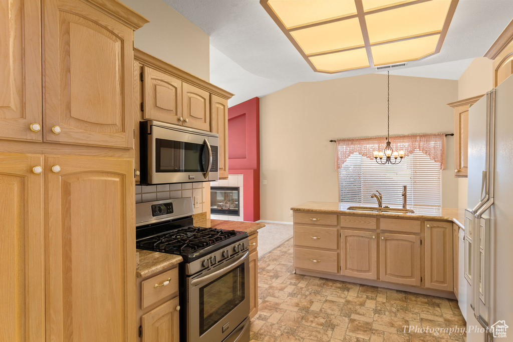 Kitchen featuring light tile floors, sink, a notable chandelier, stainless steel appliances, and pendant lighting