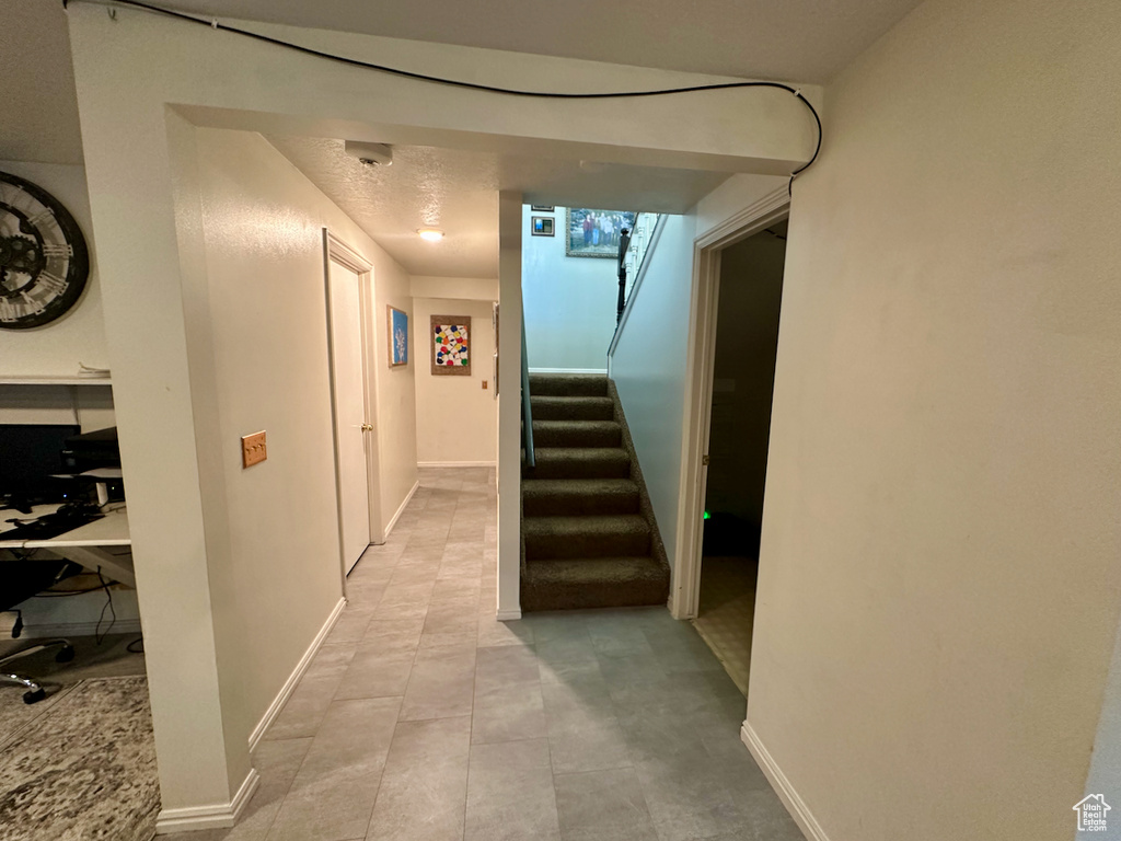Hallway featuring light tile floors
