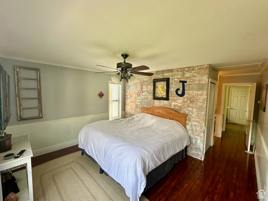 Bedroom featuring dark hardwood / wood-style floors, ceiling fan, and crown molding