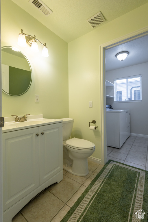 Bathroom featuring vanity, toilet, tile floors, and a textured ceiling