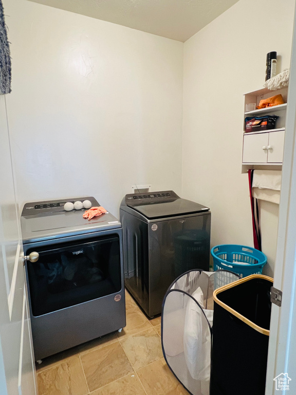 Laundry area with independent washer and dryer and light tile floors