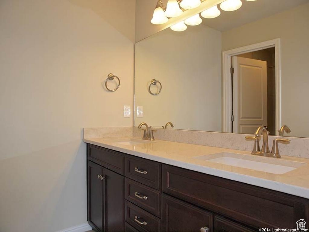 Bathroom featuring vanity with extensive cabinet space and dual sinks