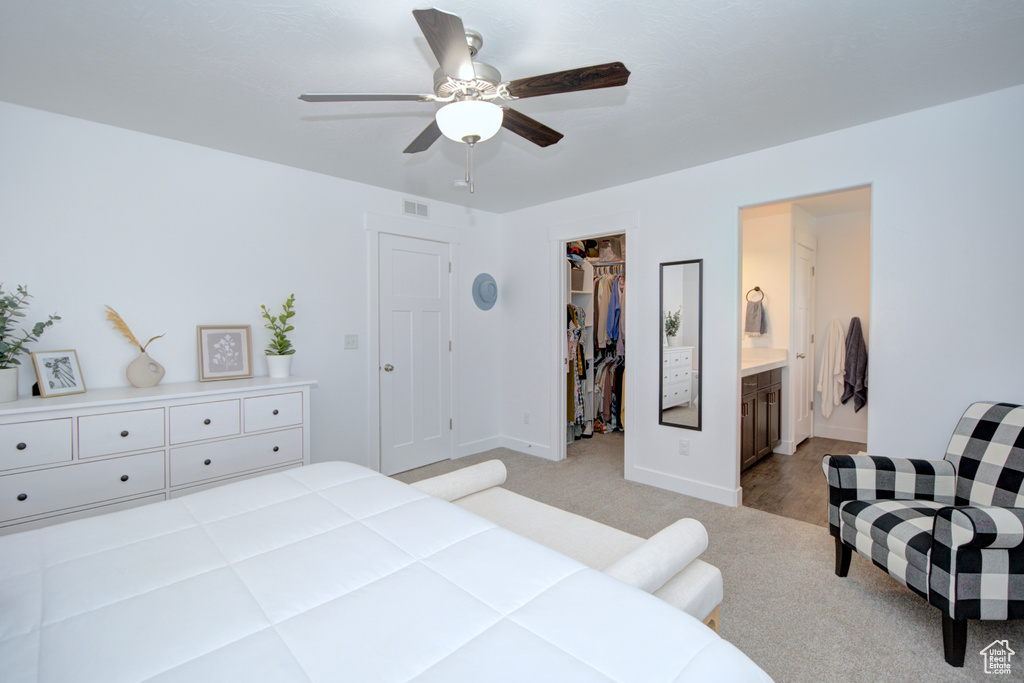 Carpeted bedroom with a closet, ceiling fan, a walk in closet, and connected bathroom