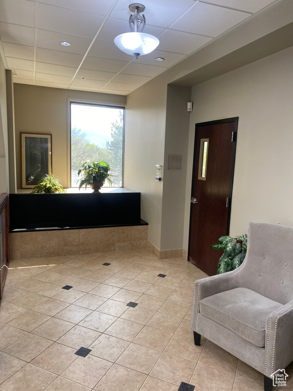 Interior space with a drop ceiling and light tile floors