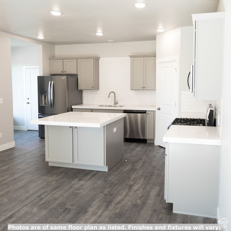 Kitchen with a center island, sink, tasteful backsplash, stainless steel appliances, and dark hardwood / wood-style floors