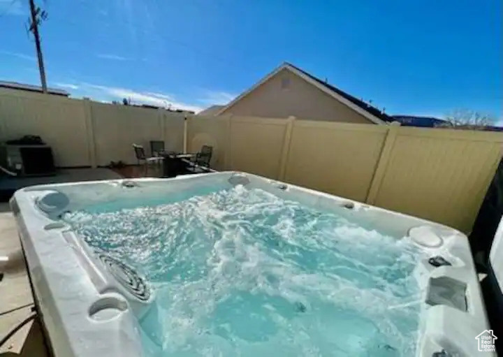 View of pool with a hot tub