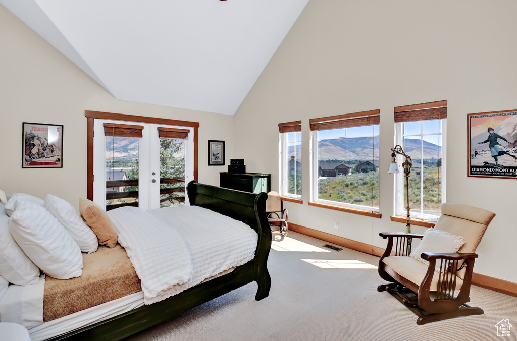 Carpeted bedroom featuring high vaulted ceiling, a mountain view, french doors, and access to exterior