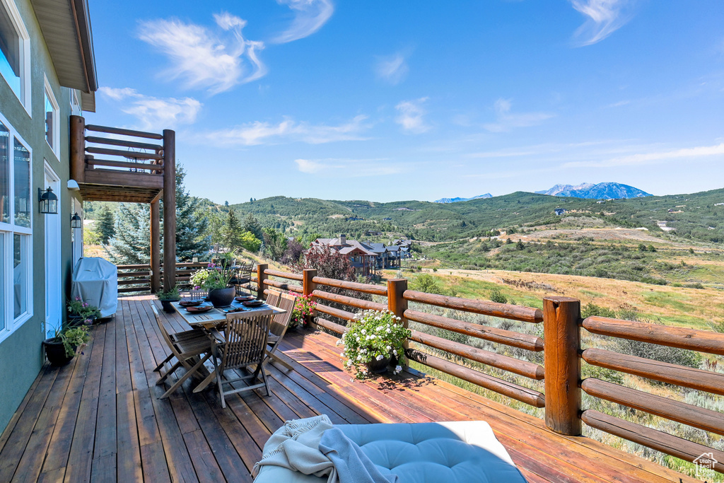 Wooden deck with a mountain view and area for grilling