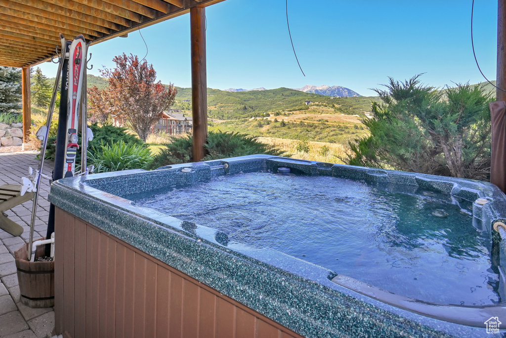 View of pool featuring a hot tub and a mountain view