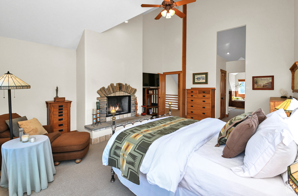Bedroom with high vaulted ceiling, light colored carpet, and ceiling fan