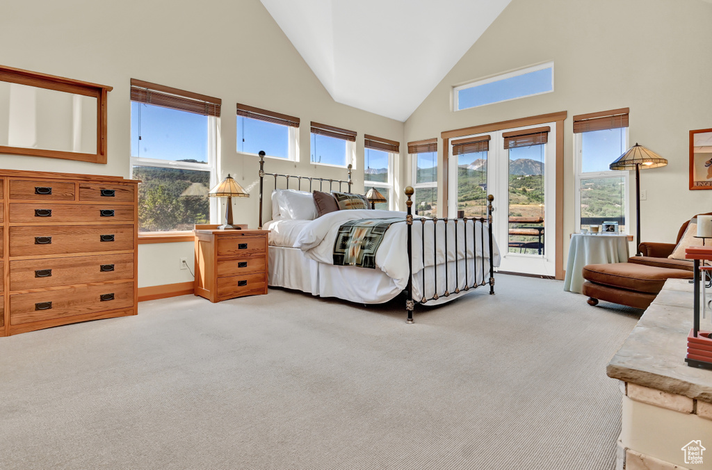 Carpeted bedroom with high vaulted ceiling, access to outside, french doors, and multiple windows