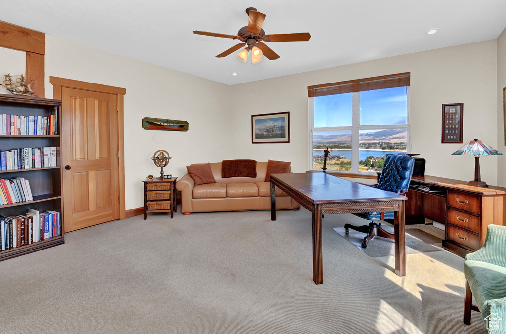 Office featuring light colored carpet, ceiling fan, and a water view