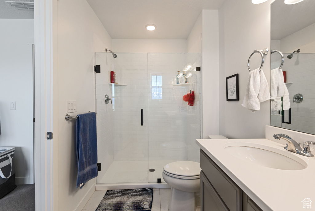 Bathroom featuring walk in shower, oversized vanity, toilet, and tile floors
