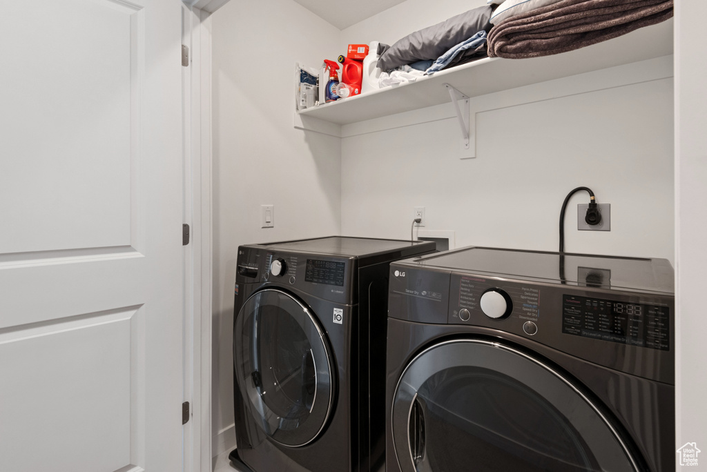 Clothes washing area featuring hookup for an electric dryer, washing machine and dryer, and washer hookup