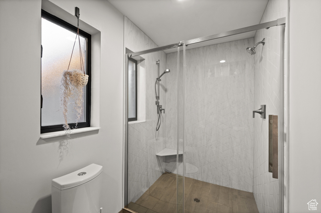 Bathroom featuring walk in shower, a healthy amount of sunlight, and toilet