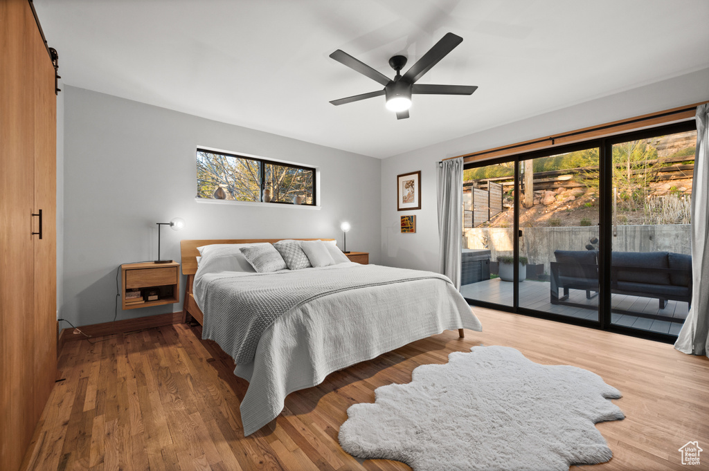 Bedroom featuring ceiling fan, dark hardwood / wood-style flooring, and access to exterior