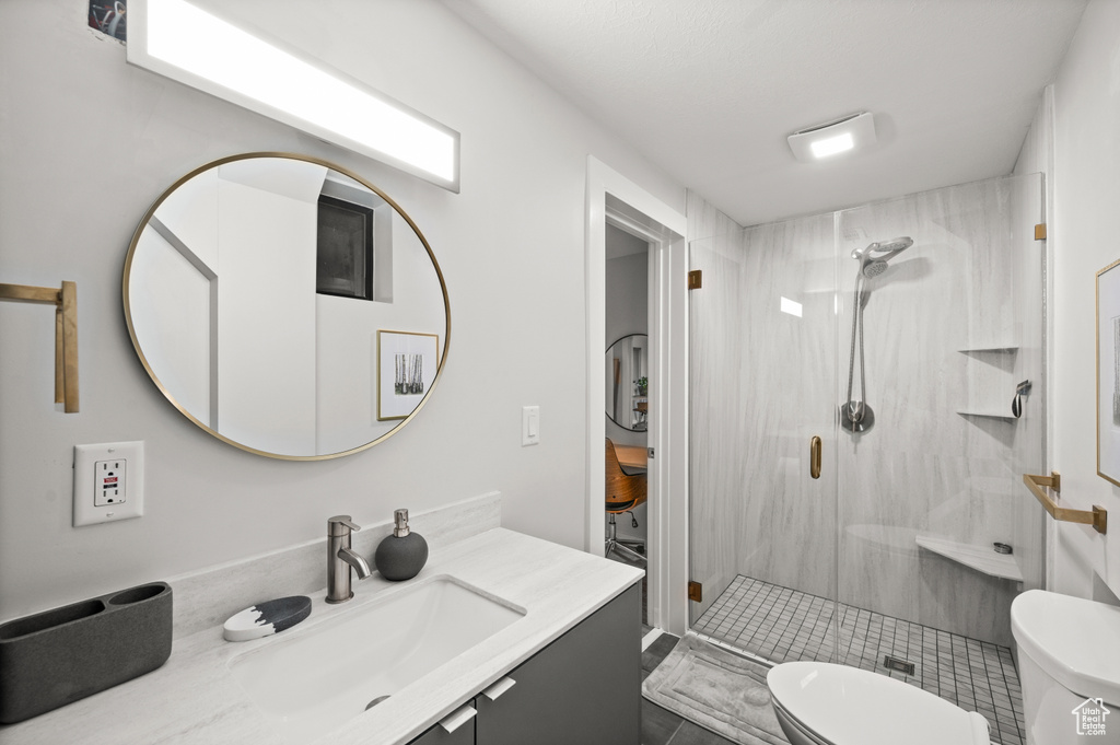 Bathroom featuring walk in shower, toilet, tile flooring, and vanity