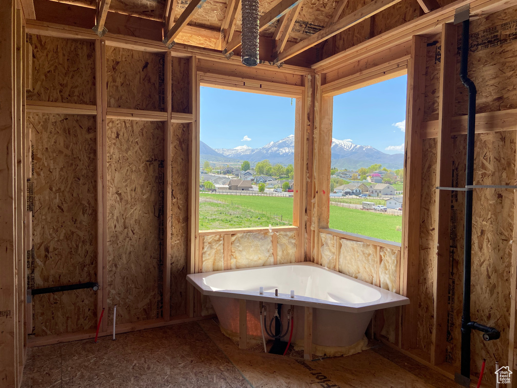 Bathroom featuring a healthy amount of sunlight, a mountain view, and a bathtub