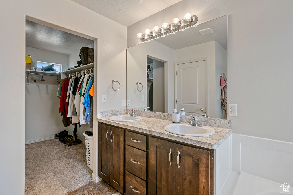 Bathroom featuring double vanity and a textured ceiling