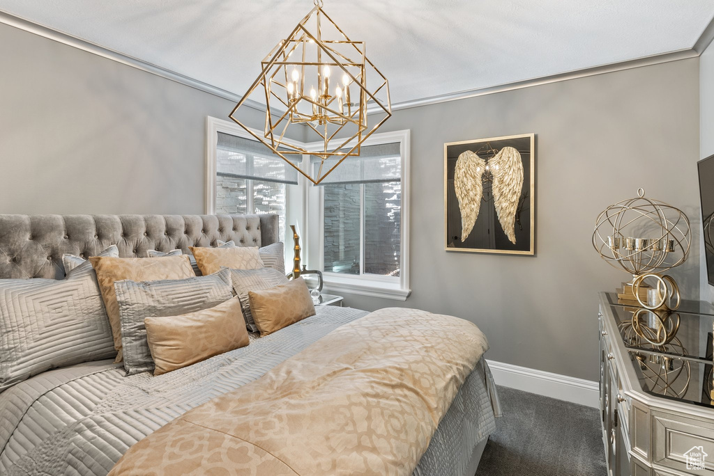 Bedroom featuring dark carpet, a chandelier, and ornamental molding