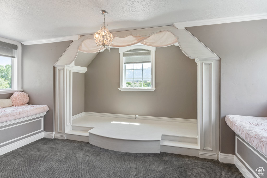Bathroom featuring a healthy amount of sunlight, a textured ceiling, and an inviting chandelier
