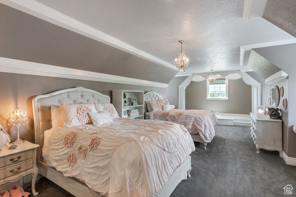 Carpeted bedroom featuring a notable chandelier, vaulted ceiling, and a textured ceiling